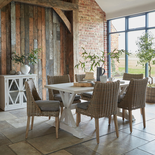 Amalfi outdoor dining chairs arranged around a white dining table in a rustic dining setting