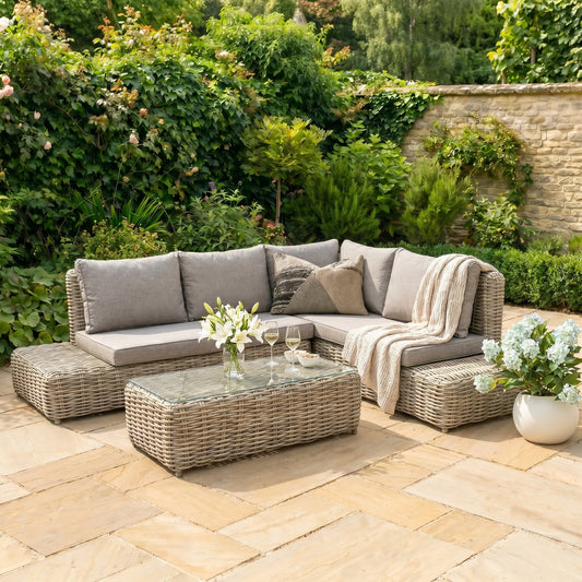 Amalfi outdoor large corner sofa set with beige woven base, cushions and glass-top coffee table on a garden patio