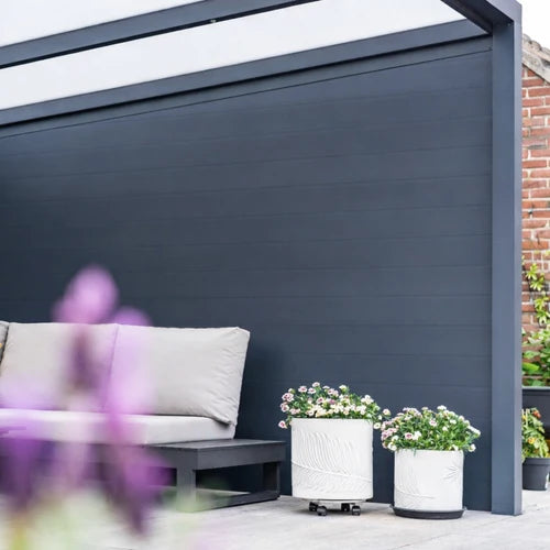 Full-height anthracite Grillo aluminium privacy wall beside an outdoor seating area